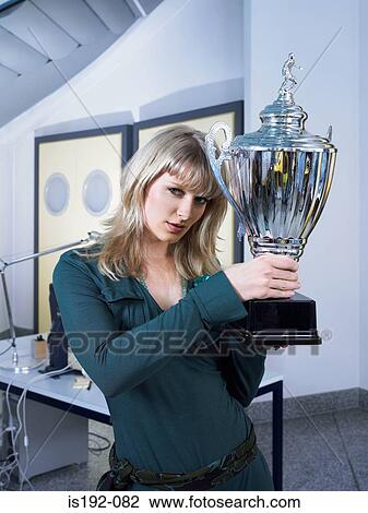 Stock Image - Woman holding a trophy. Fotosearch