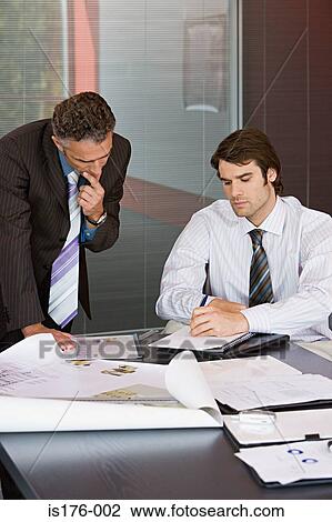 Businessmen studying plans View Large Photo Image Stock Image - Businessmen studying plans. Fotosearch