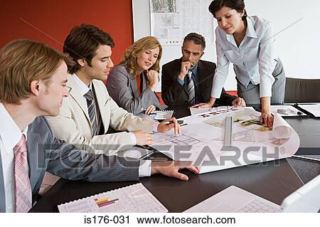 Businesspeople looking at plans View Large Photo Image Stock Image - Businesspeople looking at plans. Fotosearch