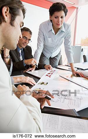 Businesspeople looking at plans View Large Photo Image Stock Image - Businesspeople looking at plans. Fotosearch