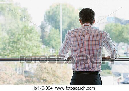 Man looking out of the window View Large Photo Image Picture - Man looking out of the window. Fotosearch