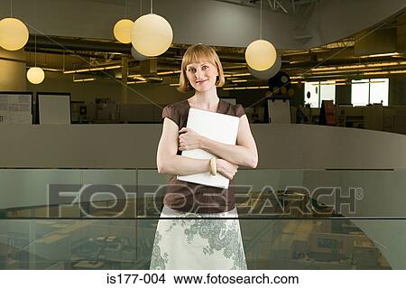Picture - Woman clutching laptop computer. Fotosearch