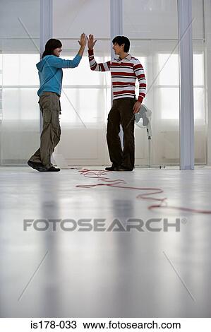 Colleagues doing a high five View Large Photo Image Stock Image - Colleagues doing a high five. Fotosearch