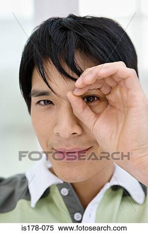 Stock Photography - Man looking through hand. Fotosearch