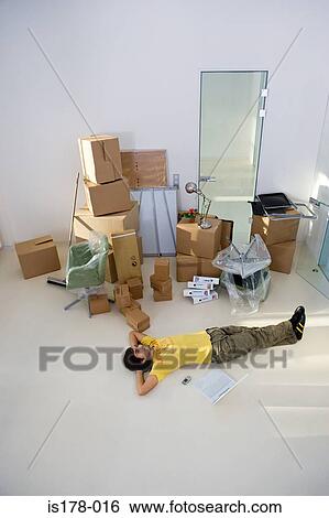 Man lying on floor of new office View Large Photo Image Stock Photograph - Man lying on floor of new office. Fotosearch