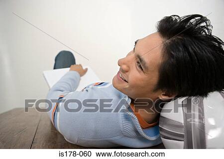 Stock Image - Man resting head on football. Fotosearch