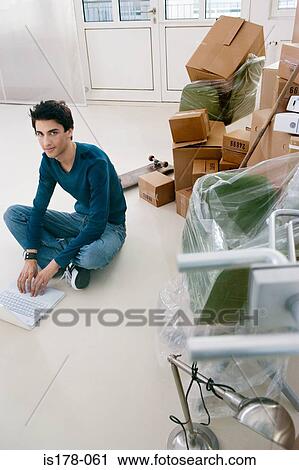 Man using laptop in new office View Large Photo Image Stock Image - Man using laptop in new office. Fotosearch
