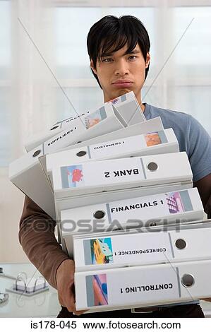 Stock Photography - Man with a pile of folders. Fotosearch
