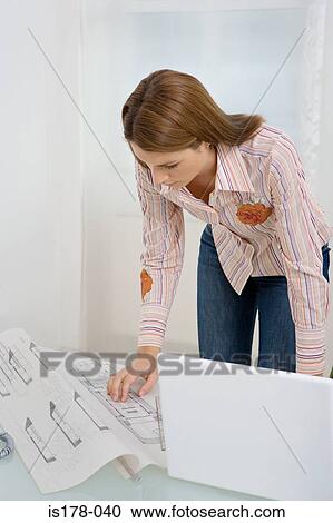 Woman looking at architectural plans View Large Photo Image Stock Image - Woman looking at architectural plans. Fotosearch