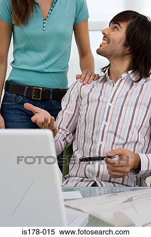 Stock Photography - Young man and female colleague. Fotosearch