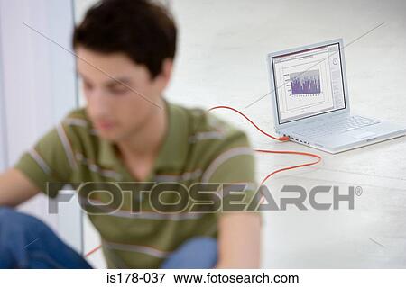 Young man by laptop View Large Photo Image Stock Photo - Young man by laptop. Fotosearch
