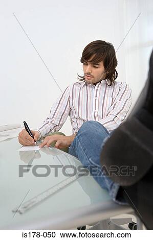 Stock Image - Young man making a note. Fotosearch