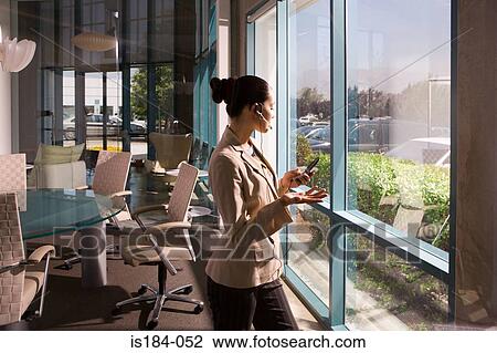Businesswoman on cell phone in meeting room View Large Photo Image Stock Image - Businesswoman on cell phone in meeting room. Fotosearch