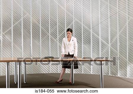Businesswoman standing by table View Large Photo Image Stock Photography - Businesswoman standing by table. Fotosearch