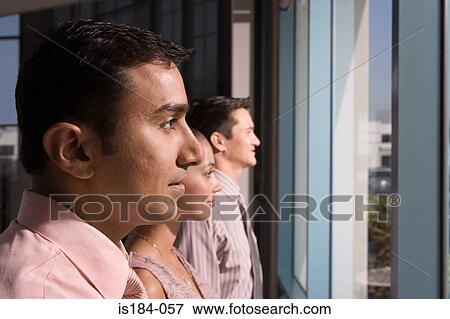 Stock Photo - Colleagues looking out of window. Fotosearch