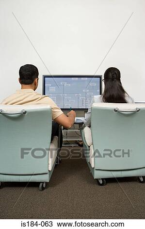 Stock Image - Colleagues watching presentation. Fotosearch