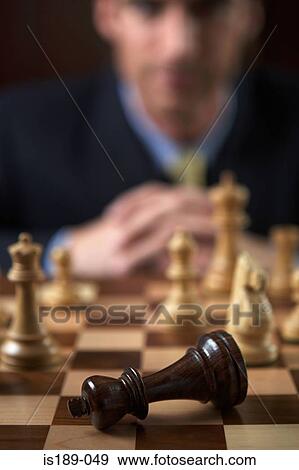 Stock Photo - Businessman playing a game of chess. Fotosearch