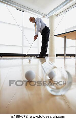 Businessman practicing putting View Large Photo Image Stock Image - Businessman practicing putting. Fotosearch