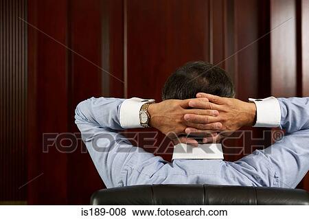 Businessman relaxing with hands behind head View Large Photo Image Stock Photo - Businessman relaxing with hands behind head. Fotosearch