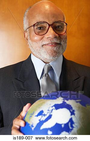 Stock Photo - Ceo holding a globe. Fotosearch