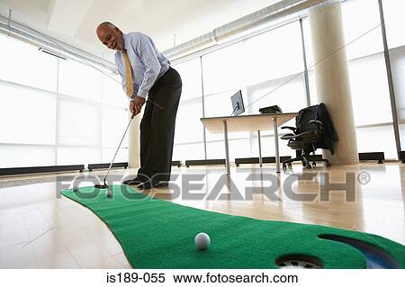 Stock Photography - Ceo practicing putting. Fotosearch