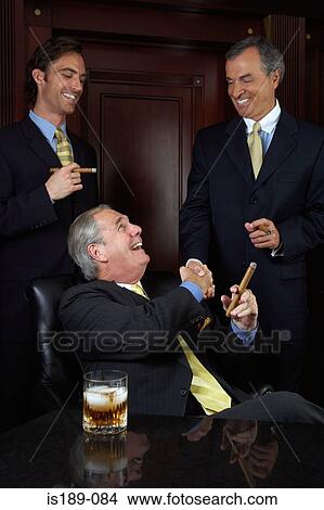 Three businessmen celebrating with cigars View Large Photo Image Picture - Three businessmen celebrating with cigars. Fotosearch