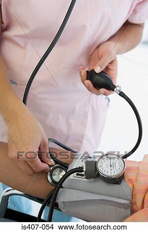 Nurse taking patients blood pressure View Large Photo Image Picture - Nurse taking patients blood pressure. Fotosearch