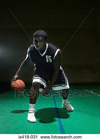 Stock Image - Basketball player dribbling the ball. Fotosearch