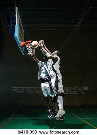 Stock Image - Basketball players by hoop. Fotosearch