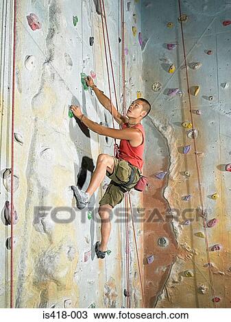 Man on climbing wall View Large Photo Image Stock Image - Man on climbing wall. Fotosearch