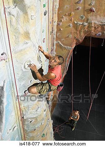 Stock Photo - Man on climbing wall. Fotosearch