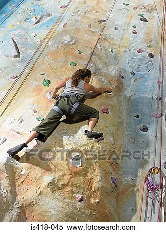 Stock Photography - Woman on climbing wall. Fotosearch
