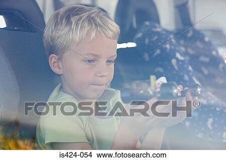 Boy sat in car holding toy car View Large Photo Image Picture - Boy sat in car holding toy car. Fotosearch