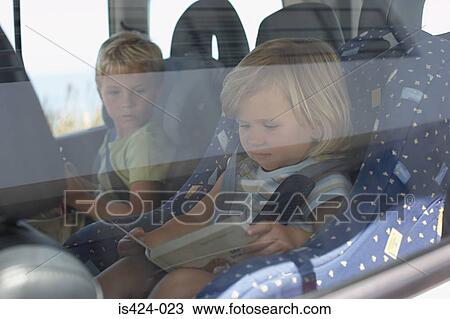 Stock Image - Brother and sister sat in car. Fotosearch