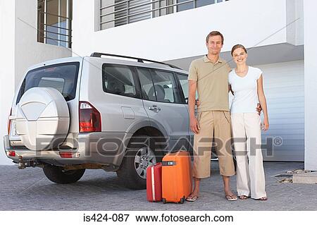 Couple stood by car with suitcases View Large Photo Image Stock Photo - Couple stood by car with suitcases. Fotosearch