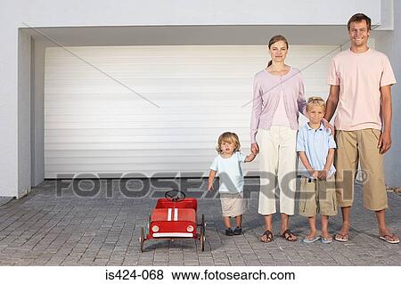 Stock Photo - Family stood in a row on driveway with toy car. Fotosearch