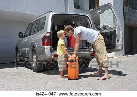 Father and son putting suitcases in car View Large Photo Image Stock Photo - Father and son putting suitcases in car. Fotosearch
