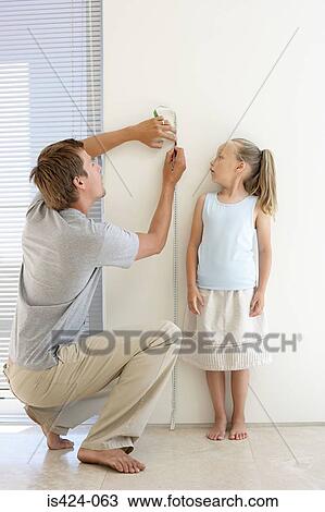 Father measuring daughters height View Large Photo Image Stock Image - Father measuring daughters height. Fotosearch