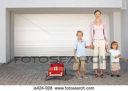 Stock Photo - Mother and children stood outside garage. Fotosearch