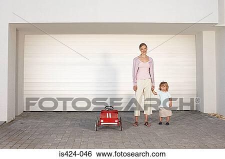 Mother and daughter stood in driveway View Large Photo Image Stock Photograph - Mother and daughter stood in driveway. Fotosearch