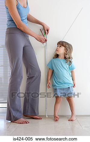 Mother measuring daughters height View Large Photo Image Stock Photography - Mother measuring daughters height. Fotosearch