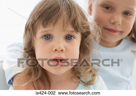 Stock Image - Portrait of two young sisters. Fotosearch