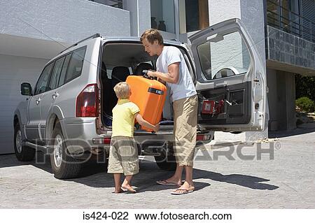 Stock Image - Son helping his father pack the car. Fotosearch