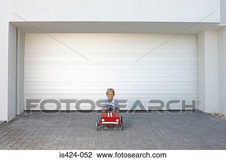 Young boy sat in a toy car View Large Photo Image Stock Image - Young boy sat in a toy car. Fotosearch
