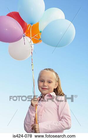 Young girl holding a bunch of balloons View Large Photo Image Stock Photo - Young girl holding a bunch of balloons. Fotosearch