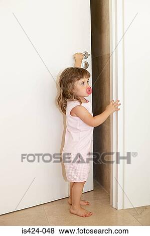 Young girl opening door View Large Photo Image Stock Photo - Young girl opening door. Fotosearch