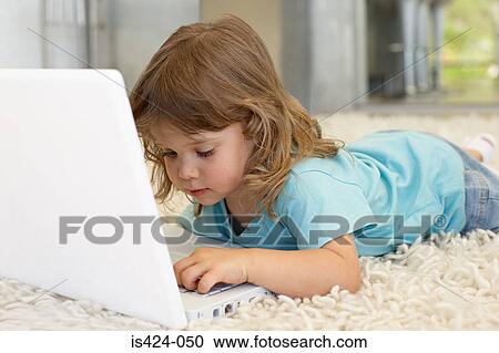 Stock Image - Young girl using a laptop computer. Fotosearch
