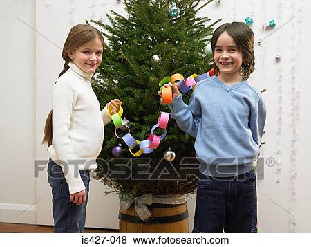 Brother and sister decorating christmas tree View Large Photo Image Stock Photo - Brother and sister decorating christmas tree. Fotosearch