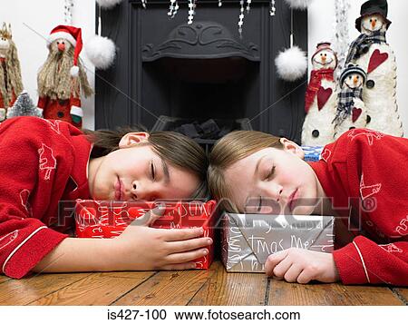 Children sleeping holding onto their presents View Large Photo Image Stock Image - Children sleeping holding onto their presents. Fotosearch