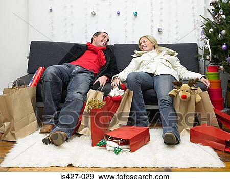 Stock Photo - Couple exhausted after christmas shopping. Fotosearch